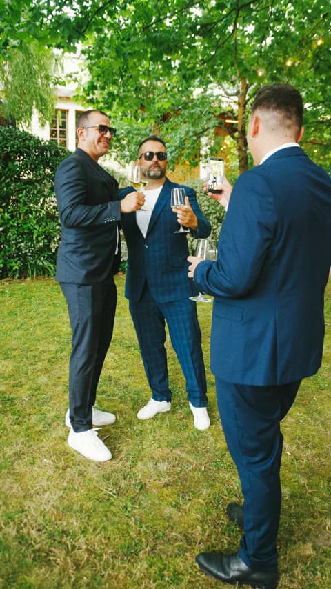 Amigos brindando con copas de vino en el jardín tras una boda con Nostra Notte.